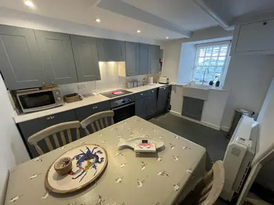 a kitchen with a table with a plate on it at Beach Hill Cottage in Portloe