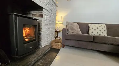 a living room with a couch and a fireplace at Beach Hill Cottage in Portloe