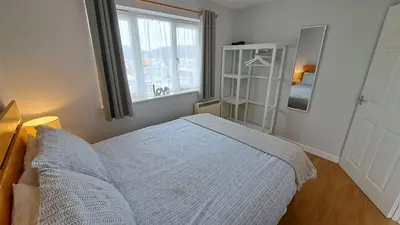 a bedroom with a bed and a window at Pelyn in Saint Mawes