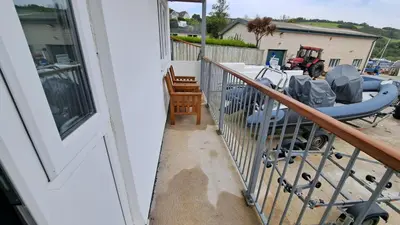 a balcony with a boat on a yard at Pelyn in Saint Mawes