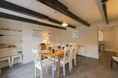 a dining room with a wooden table and chairs at April Cottage in Saint Just in Roseland