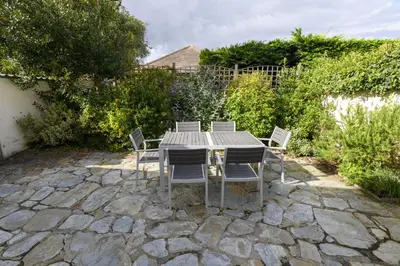 a table and chairs on a stone patio at April Cottage in Saint Just in Roseland