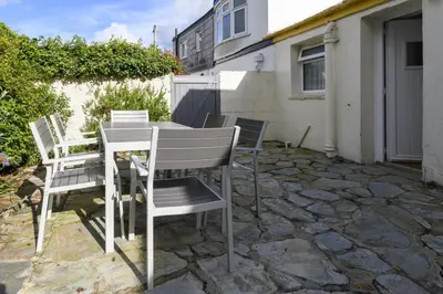a table and chairs sitting on a stone patio at April Cottage in Saint Just in Roseland