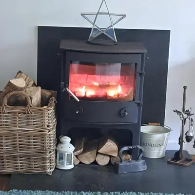 a fireplace on a table with a basket of logs at The Dovecote in Launceston