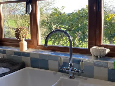 a kitchen sink with a faucet in front of a window at The Dovecote in Launceston