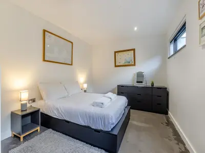 a bedroom with a large bed and a dresser at Tregarden in Bude