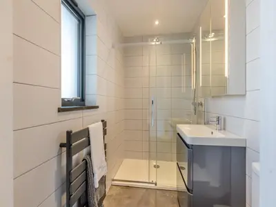 a bathroom with a glass shower and a sink at Tregarden in Bude