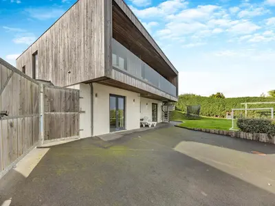 an external view of a house with a wooden facade at Tregarden in Bude