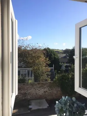 an open window with a view of a garden at Chy Bownder Cottage in Lostwithiel