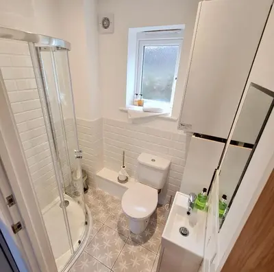 a bathroom with a toilet and a shower and a sink at Chy Bownder Cottage in Lostwithiel