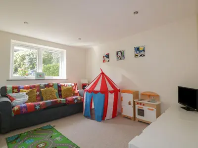 a living room with a couch and a play tent at Lower Mellan Barn in Helston