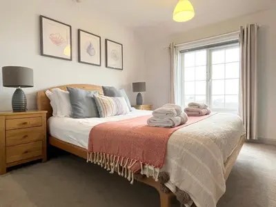 a bedroom with a bed with towels on it at Hebaska~Watergate Bay~3 Bedroom in Porth