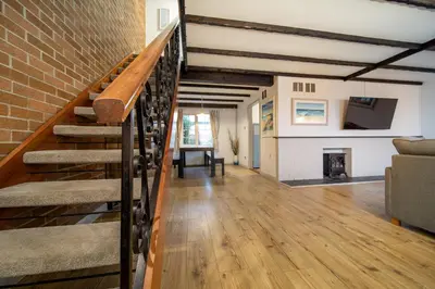 a living room with a staircase and a fireplace at Hebaska~Watergate Bay~3 Bedroom in Porth