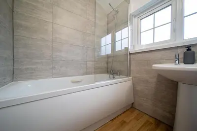 a bathroom with a bath tub and a sink at Hebaska~Watergate Bay~3 Bedroom in Porth