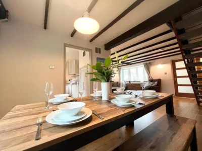 a wooden table with bowls and plates on it at Hebaska~Watergate Bay~3 Bedroom in Porth