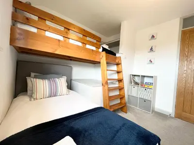 a bedroom with a bunk bed and a ladder at Hebaska~Watergate Bay~3 Bedroom in Porth