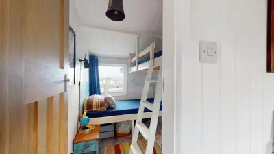 a small room with a bunk bed and a ladder at E41 Silver Mist, Riviere Towans in Hayle