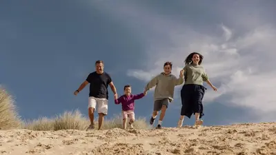 a family running on the sand on a beach at E41 Silver Mist, Riviere Towans in Hayle