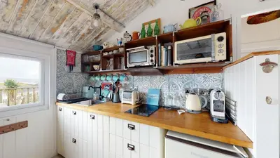 a kitchen with white cabinets and a counter top at E41 Silver Mist, Riviere Towans in Hayle