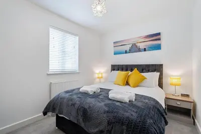 a bedroom with a bed with two towels on it at Modern House nr Gwithian Beach & St Ives in Tuckingmill