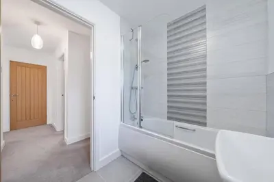 a bathroom with a shower and a white tub at Modern House nr Gwithian Beach & St Ives in Tuckingmill