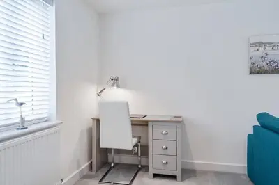 a desk with a lamp and a chair in a room at Modern House nr Gwithian Beach & St Ives in Tuckingmill