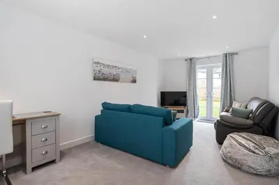 a living room with a blue couch and a chair at Modern House nr Gwithian Beach & St Ives in Tuckingmill