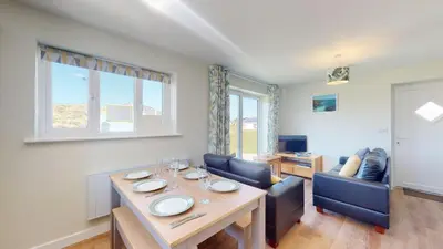 a dining room with a table and two chairs at G07 Tweenbanx, Riviere Towans in Hayle