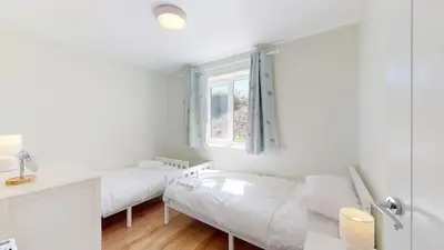 a white room with two beds and a window at G07 Tweenbanx, Riviere Towans in Hayle