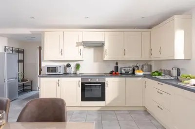 a white kitchen with white cabinets and appliances at Robins Rest - Pets welcome - Free Parking - Backgarden in Perranporth