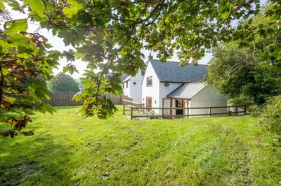 a white house in a field with a fence at Robins Rest - Pets welcome - Free Parking - Backgarden in Perranporth