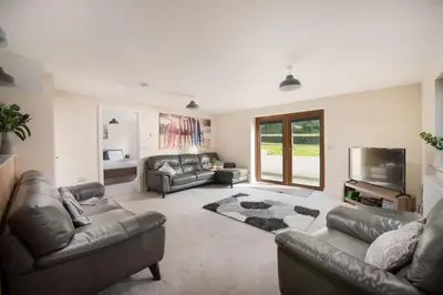 a living room with leather couches and a flat screen tv at Robins Rest - Pets welcome - Free Parking - Backgarden in Perranporth