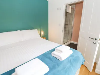 a bedroom with a bed with towels on a blue blanket at James' Place in Falmouth
