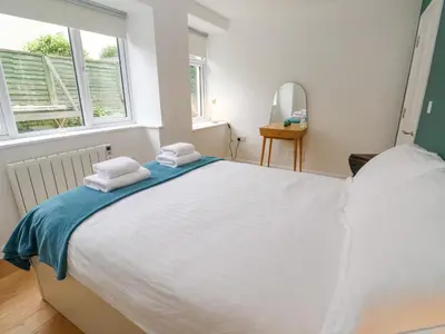 a bedroom with a large white bed with towels on it at James' Place in Falmouth