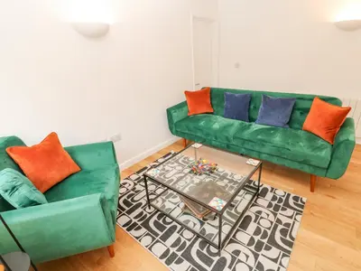 a living room with two green couches and a coffee table at James' Place in Falmouth