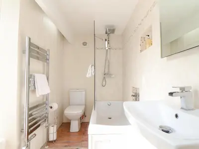 a white bathroom with a sink and a toilet at Crab Pot Cottage in Helston