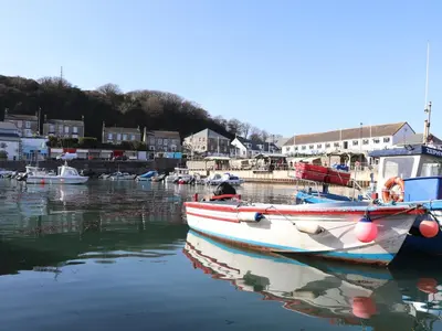 two boats docked in the water in a harbor at Crab Pot Cottage in Helston