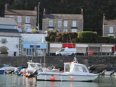 a group of boats are docked in a harbor at Crab Pot Cottage in Helston