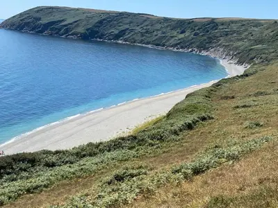 a beach on a hill next to the ocean at An Mordros 15 Polkirt Heights in Mevagissey