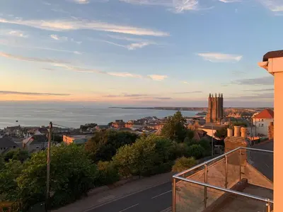 a view of a city from a balcony of a building at Newquay Sunset & Sea View Apartment in Town Centre in Newquay