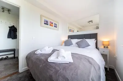 a bedroom with a bed with two towels on it at Newquay Sunset & Sea View Apartment in Town Centre in Newquay