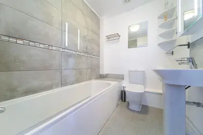 a bathroom with a tub and a sink and a toilet at Newquay Sunset & Sea View Apartment in Town Centre in Newquay