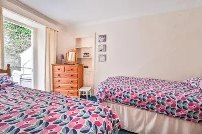 a bedroom with two beds and a window at 3Bed Apartment Sleeps 5- Parking Wifi Near Beach in Looe