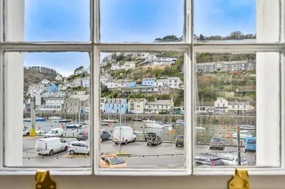 a window with a view of a parking lot at 3Bed Apartment Sleeps 5- Parking Wifi Near Beach in Looe
