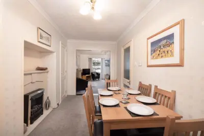 a dining room with a table and chairs and a fireplace at 3Bed Apartment Sleeps 5- Parking Wifi Near Beach in Looe