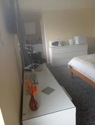 a room with a bed and a table with a tv at Self Contained Garden Annexe in Bodmin in Bodmin