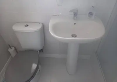 a white bathroom with a toilet and a sink at Self Contained Garden Annexe in Bodmin in Bodmin