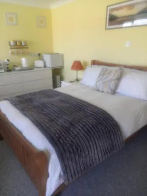 a bedroom with a bed with a blanket on it at Self Contained Garden Annexe in Bodmin in Bodmin