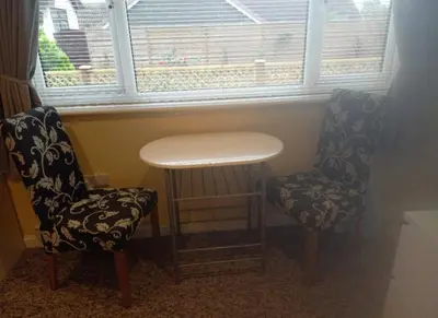 two chairs and a table in front of a window at Self Contained Garden Annexe in Bodmin in Bodmin