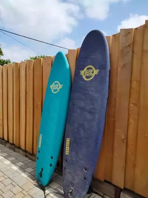 two skateboards are leaning against a wooden fence at Modern cosy apartment walking distance to many cove beaches and coast path walks as well as the famous Helford river in Falmouth